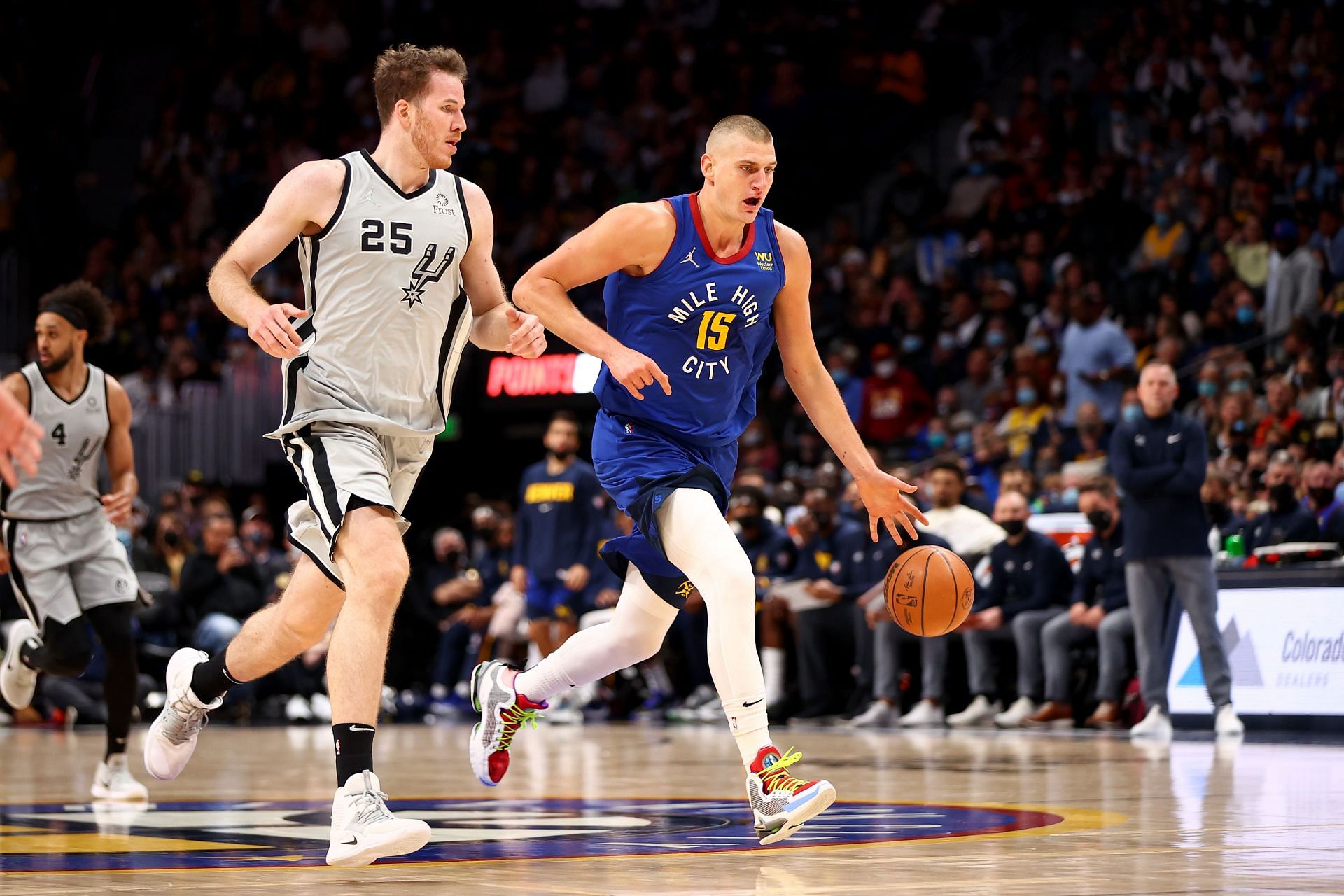 Nikola Jokic #15 of the Denver Nuggets dribbles past Jakob Poeltl.