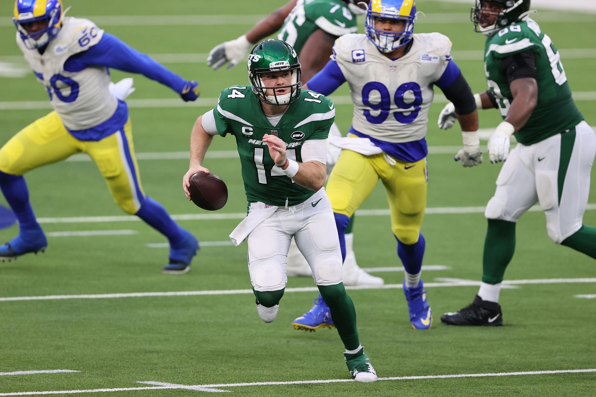 Sam Darnold (14) flees from Aaron Donald (99) in the historic 2020 meeting between the Jets and Rams