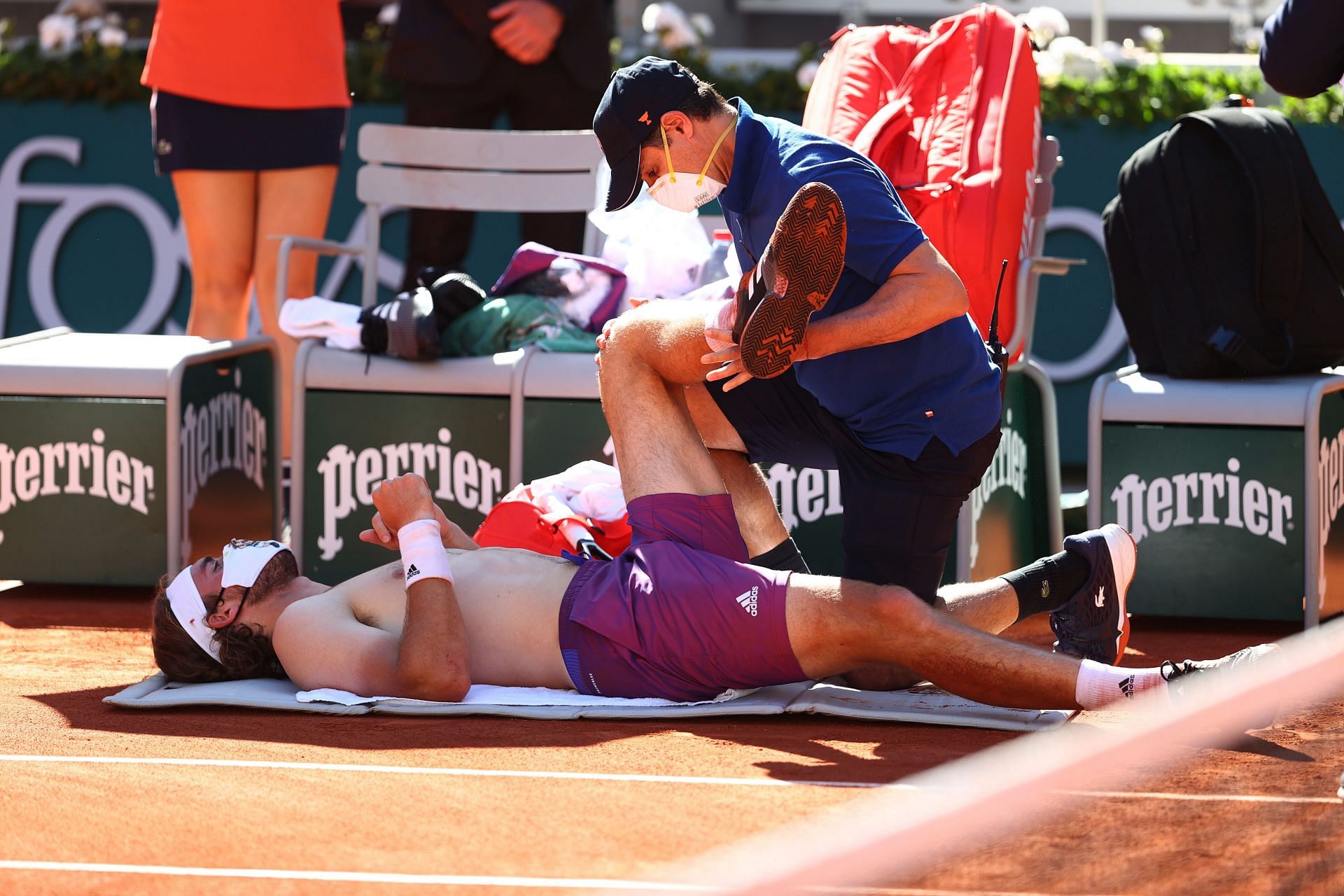 Stefanos Tsitsipas receives medical attention during a match at the 2021 French Open