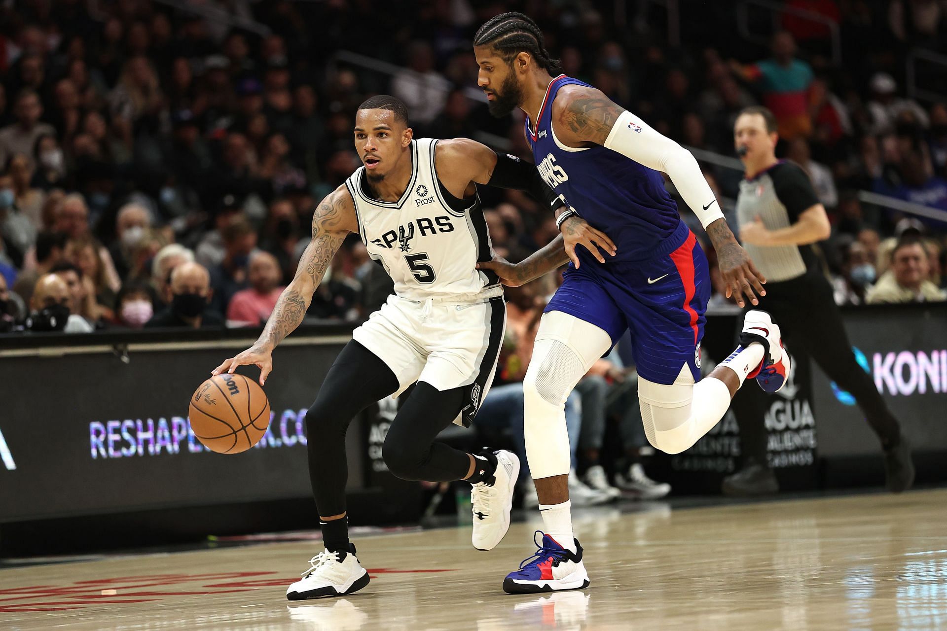 Paul George of the LA Clippers defends against Dejounte Murray of the San Antonio Spurs during the second half on November 16, 2021, in Los Angeles, California.