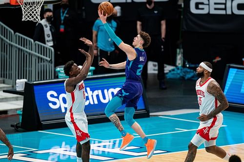 LaMelo Ball of the Charlotte Hornets drives against Jae'Sean Tate of the Houston Rockets.