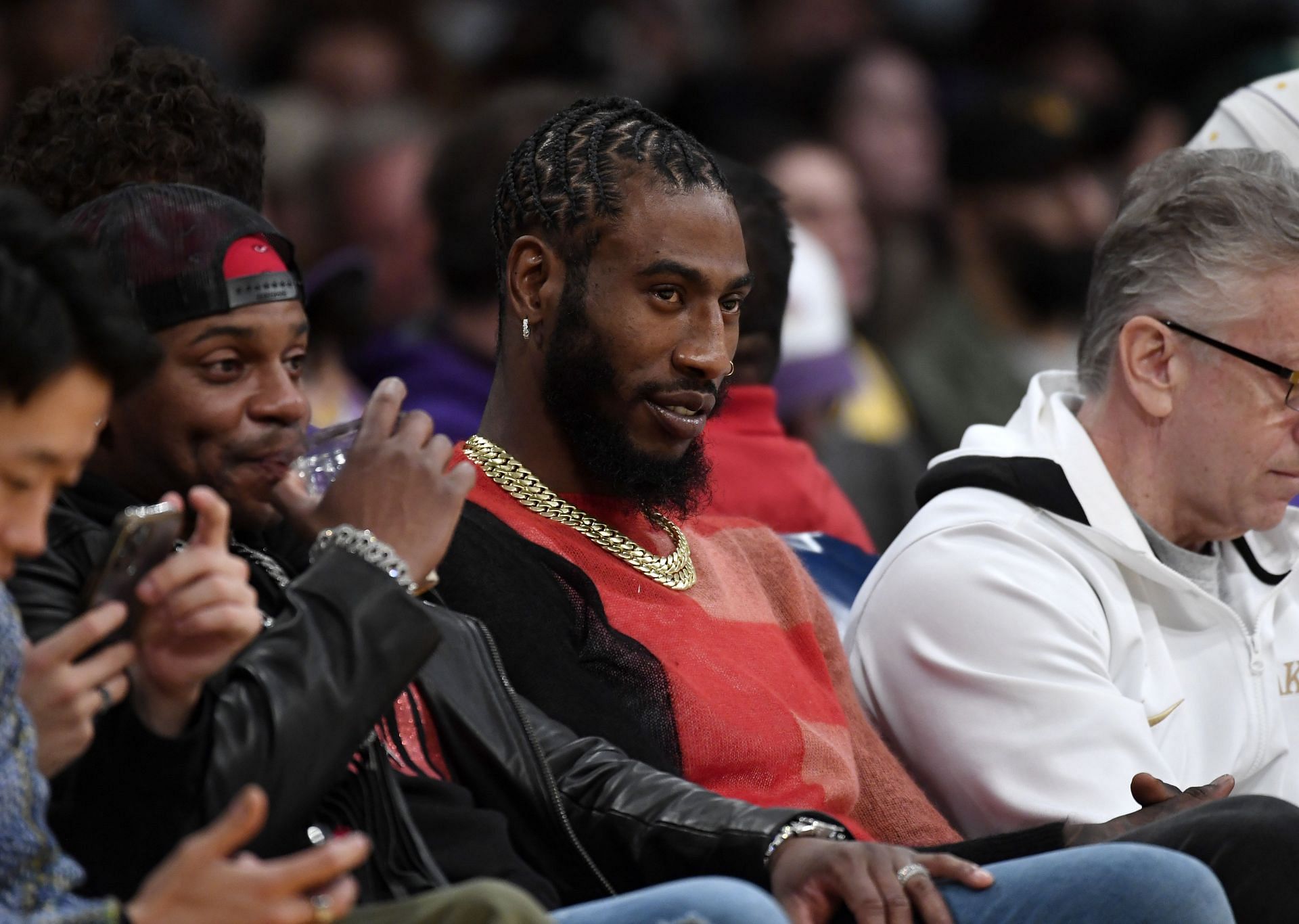 Former NBA player Iman Shumpert watching a game on the sidelines.