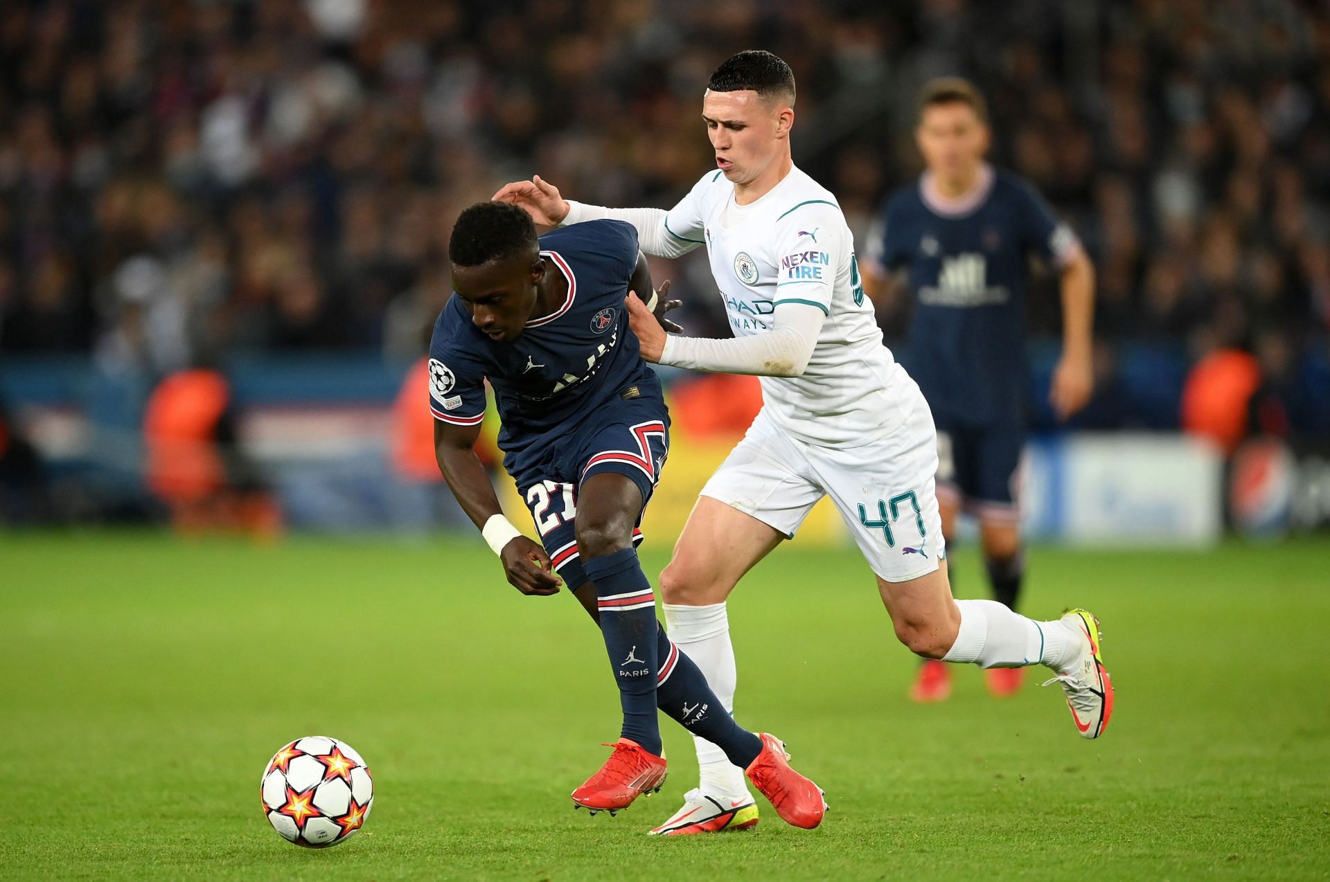 Manchester City&#039;s Phil Foden (#47) challenges Idrissa Gueye (L) of PSG