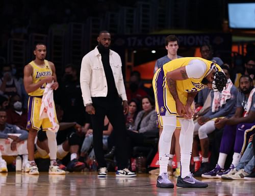 LeBron (in the back) watches Anthony Davis (front) as he clutches his finger