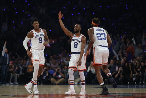 Kemba Walker #8 of the New York Knicks reacts with RJ Barrett #9 and Mitchell Robinson #23 of the New York Knicks during the first half against the Boston Celtics at Madison Square Garden on October 20, 2021 in New York City.