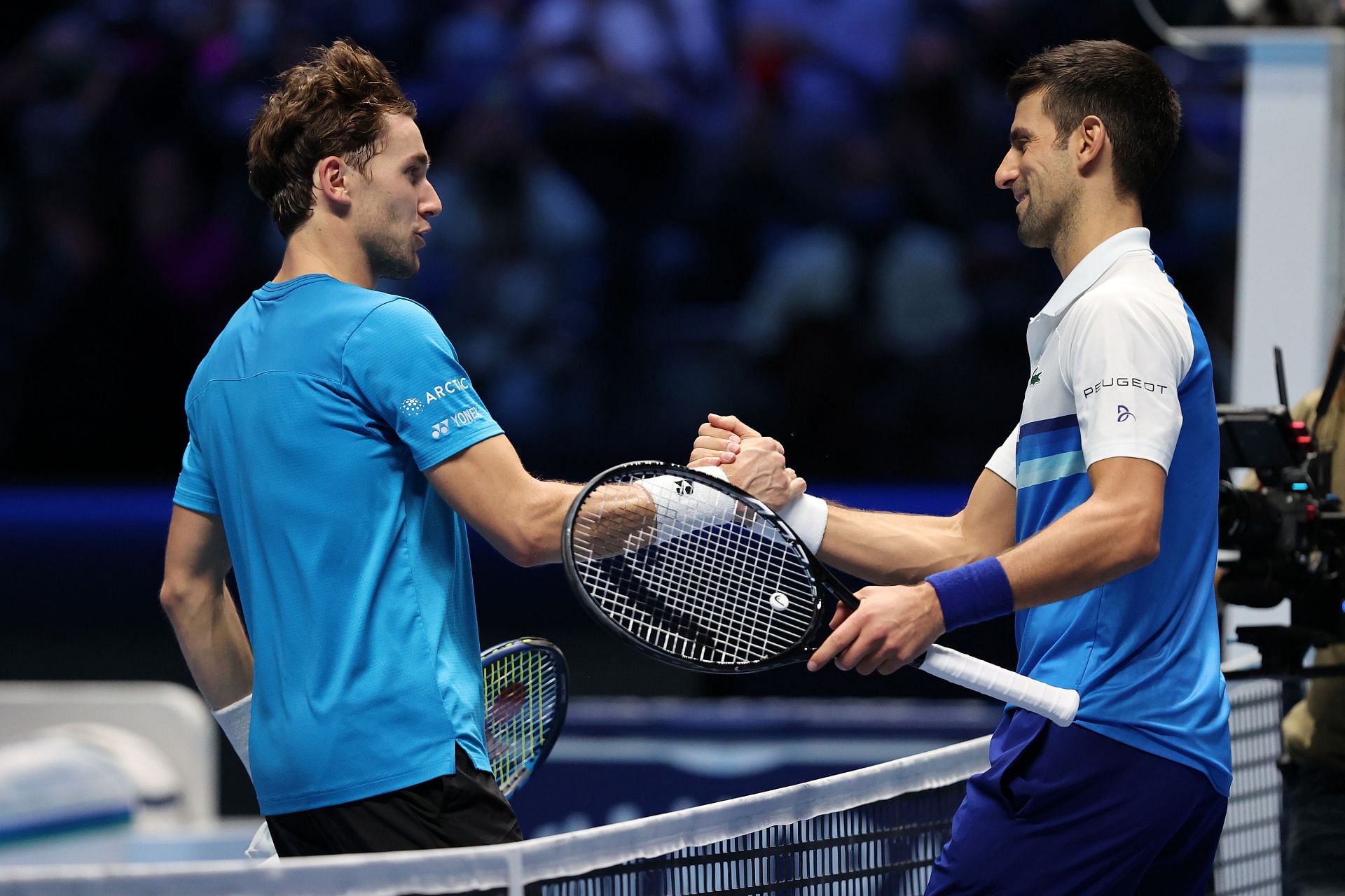 Casper Ruud (L) &amp; Novak Djokovic shake hands after their match at the ATP Finals 2021