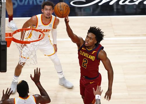 Collin Sexton of the Cleveland Cavaliers scores in front of Trae Young of the Atlanta Hawks