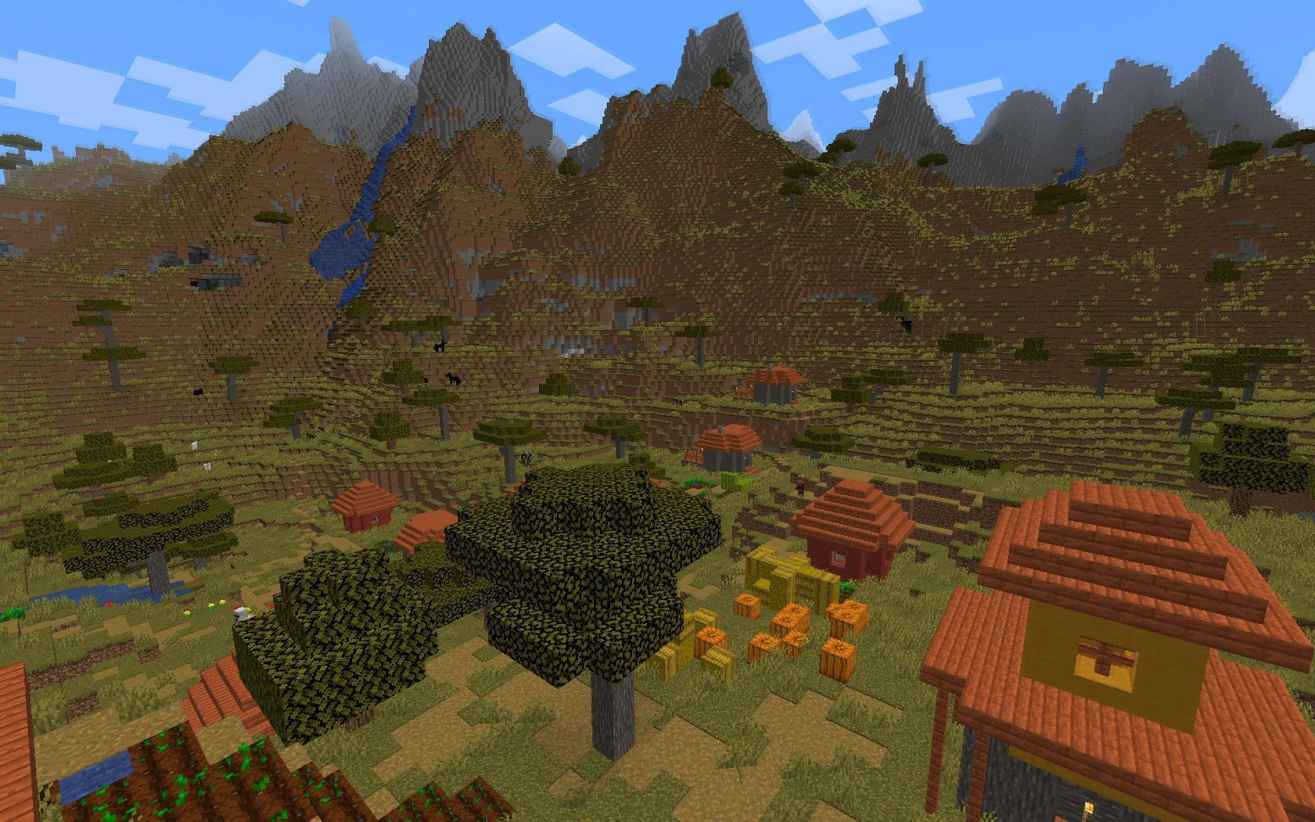 A player overlooks a savanna village in-game. (Image via Minecraft)