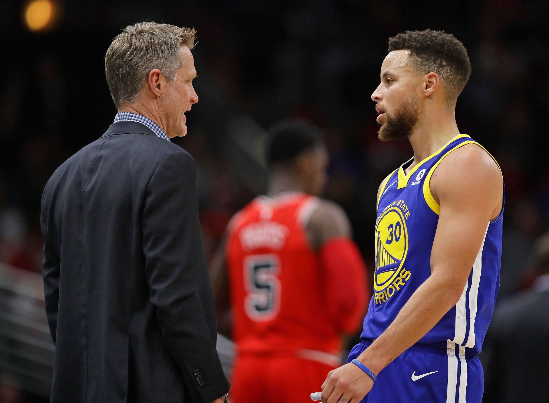 Golden State Warriors head coach Steve Kerr and Steph Curry interact during a game.