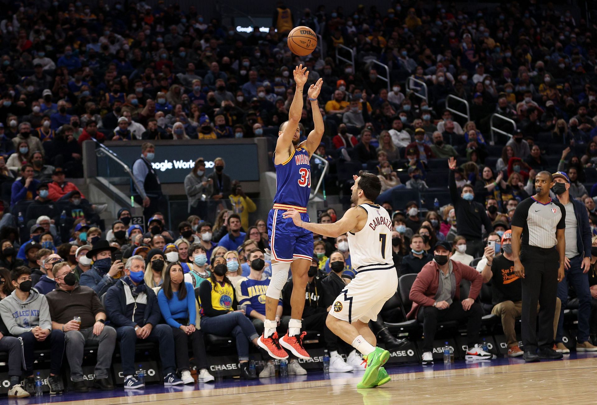 Steph Curry shoots a three-pointer over Facundo Campazzo.