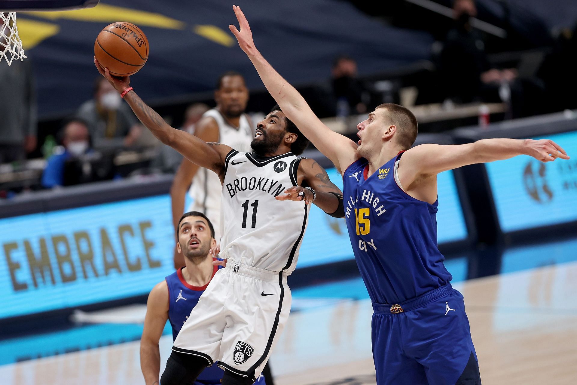 Kyrie Irving of the Brooklyn Nets drives against Nikola Jokic of the Denver Nuggets