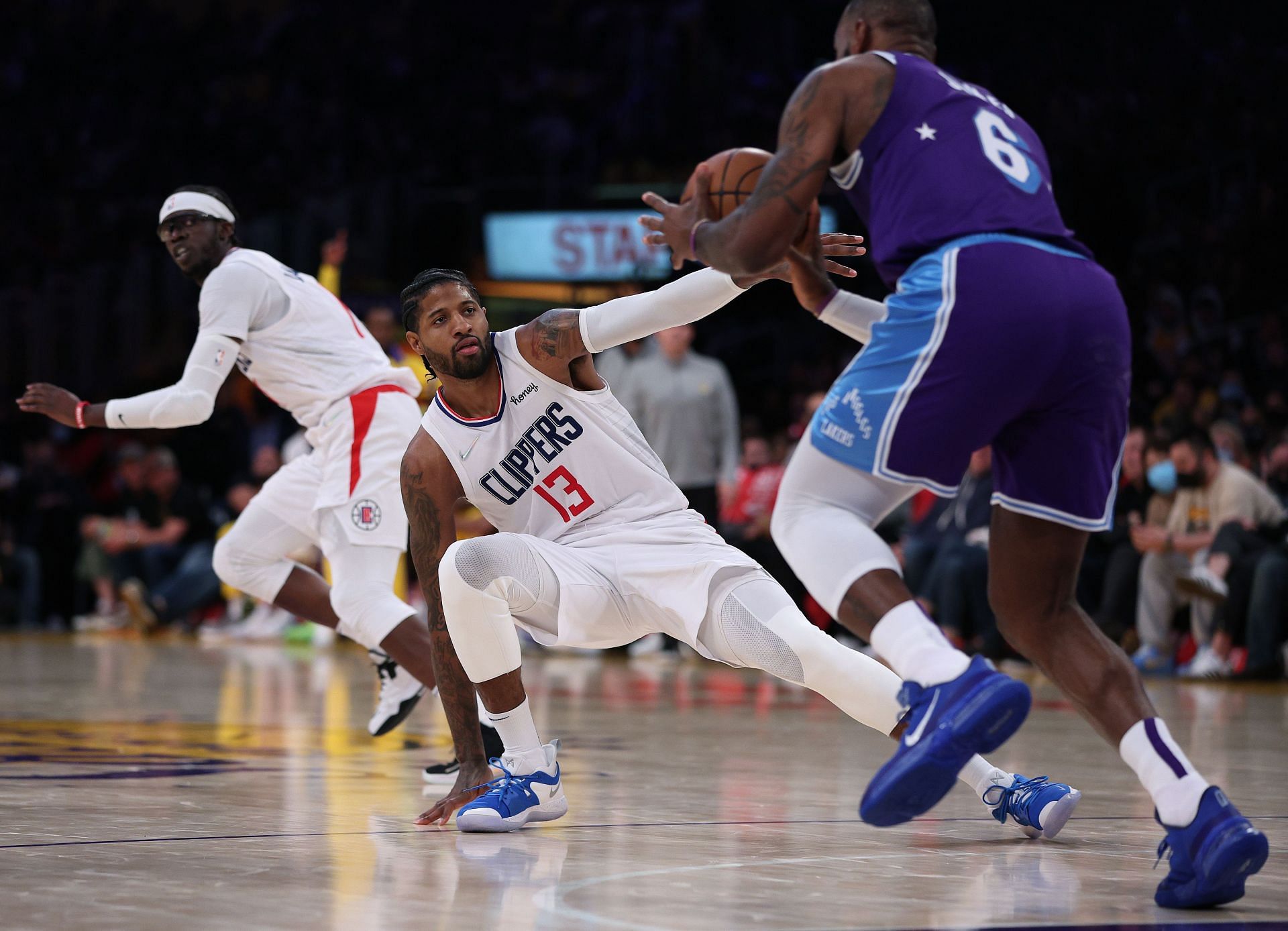 Paul George #13 and Reggie Jackson #1 of the LA Clippers scramble back on defense as LeBron James #6 of the Los Angeles Lakers dribbles the ball.