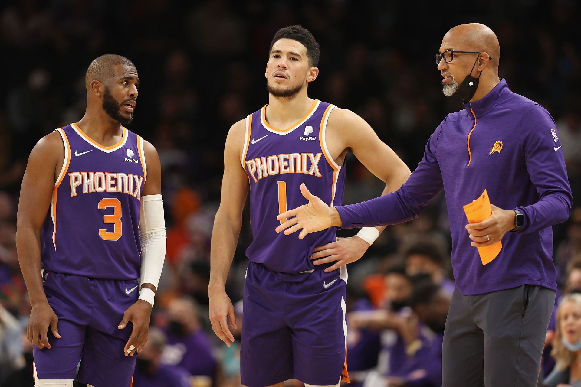 Head coach Monty Williams of the Phoenix Suns talks with Chris Paul #3 and Devin Booker #1