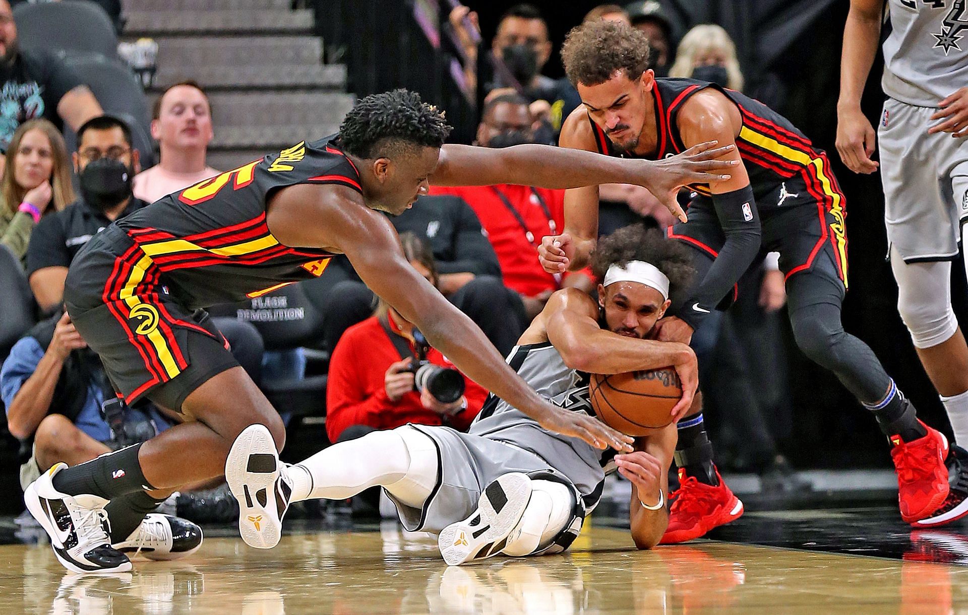 Trae Young and Clint Capela of the Atlanta Hawks fight for a loose ball against the San Antonio Spurs.