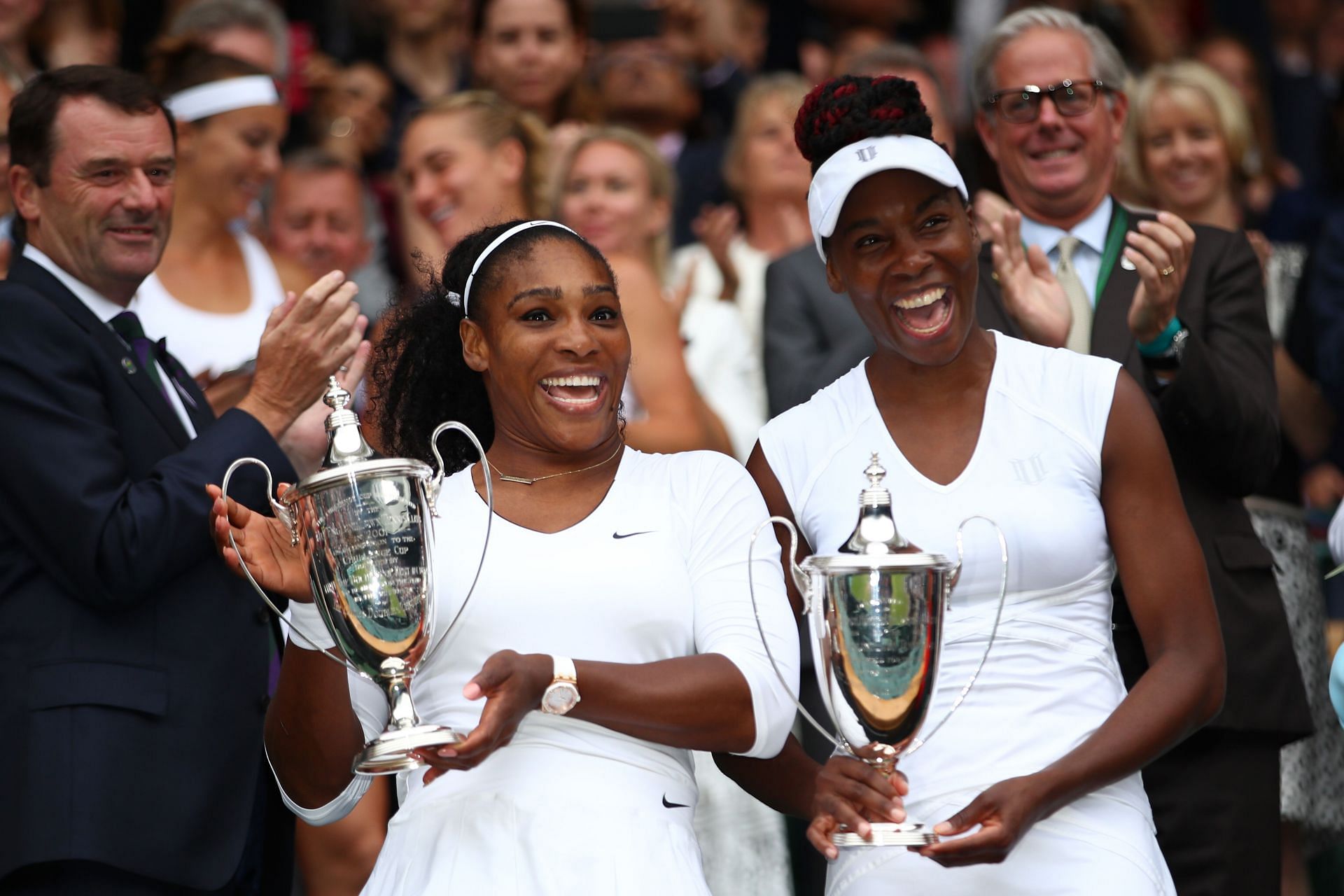 Serena Williams and Venus Williams with their doubles trophies at Wimbledon 2016