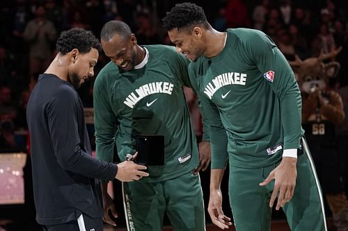 Bryn Forbes #7 of the San Antonio Spurs reacts with Khris Middleton #22 and Giannis Antetokounmpo #34 of the Milwaukee Bucks after receiving his 2021 NBA Championship ring