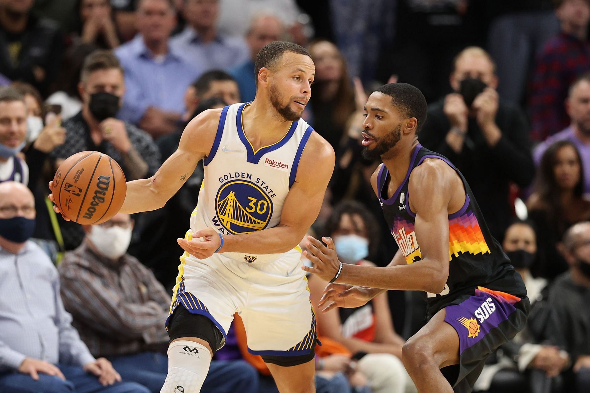 Stephen Curry #30 of the Golden State Warriors handles the ball against Mikal Bridges #25 of the Phoenix Suns