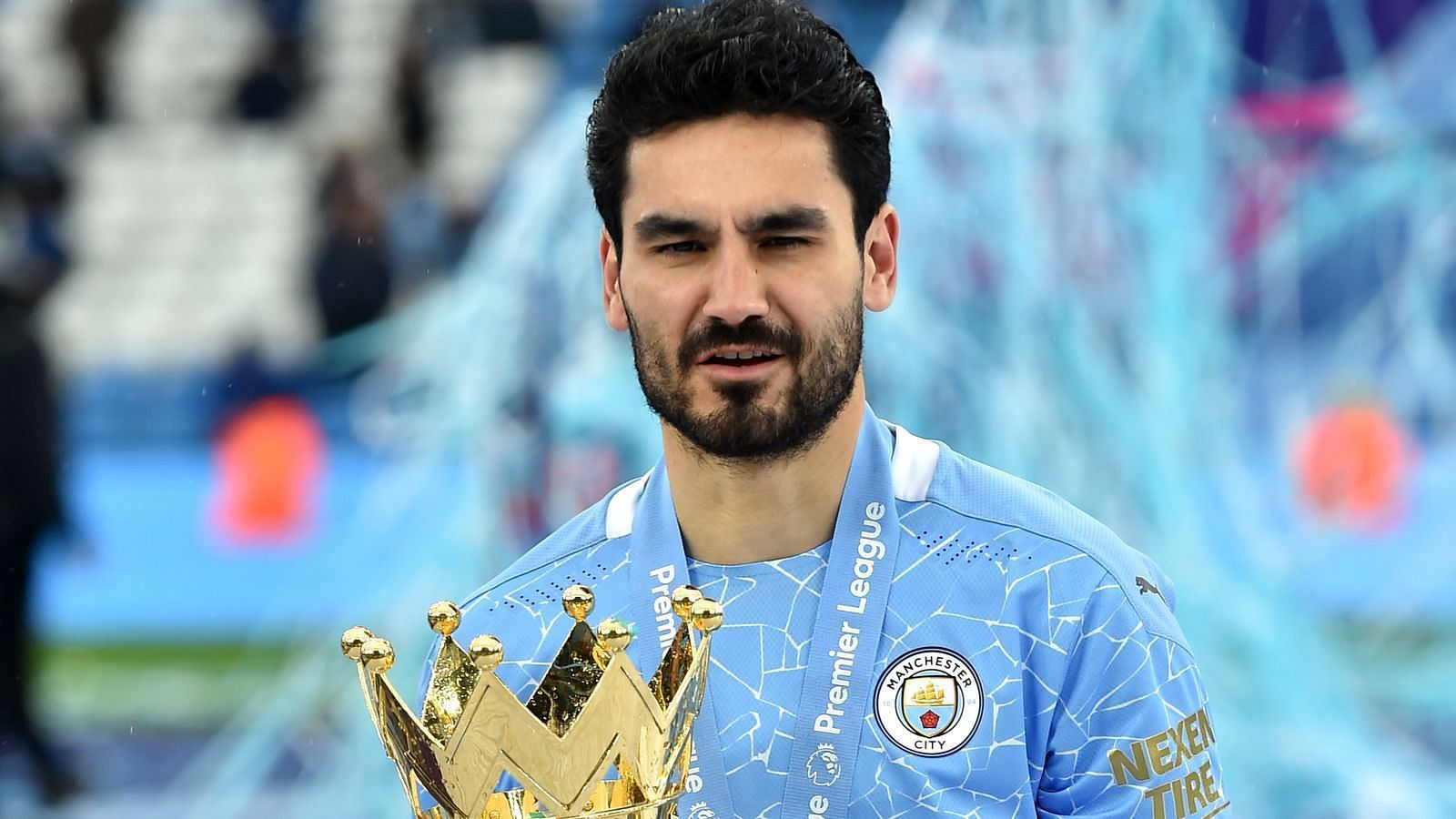 Ilkay Gundogan posing with the Premier League trophy