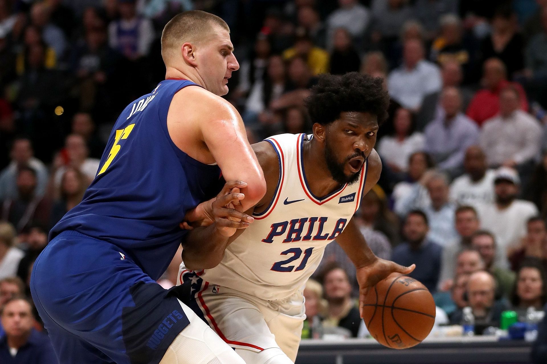 Philadelphia 76ers center Joel Embiid with the ball trying to get past Denver Nuggets big man Nikola Jokic