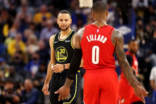 Steph Curry #30 of the Golden State Warriors talks with Damian Lillard #0 of the Portland Trail Blazers during the first half of the game at Chase Center on November 26, 2021 in San Francisco, California.