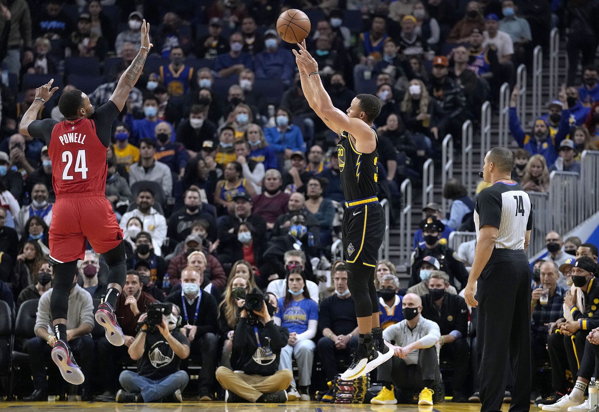 Stephen Curry #30 of the Golden State Warriors shoots a three-point shot against Norman Powell #24 of the Portland Trail Blazers