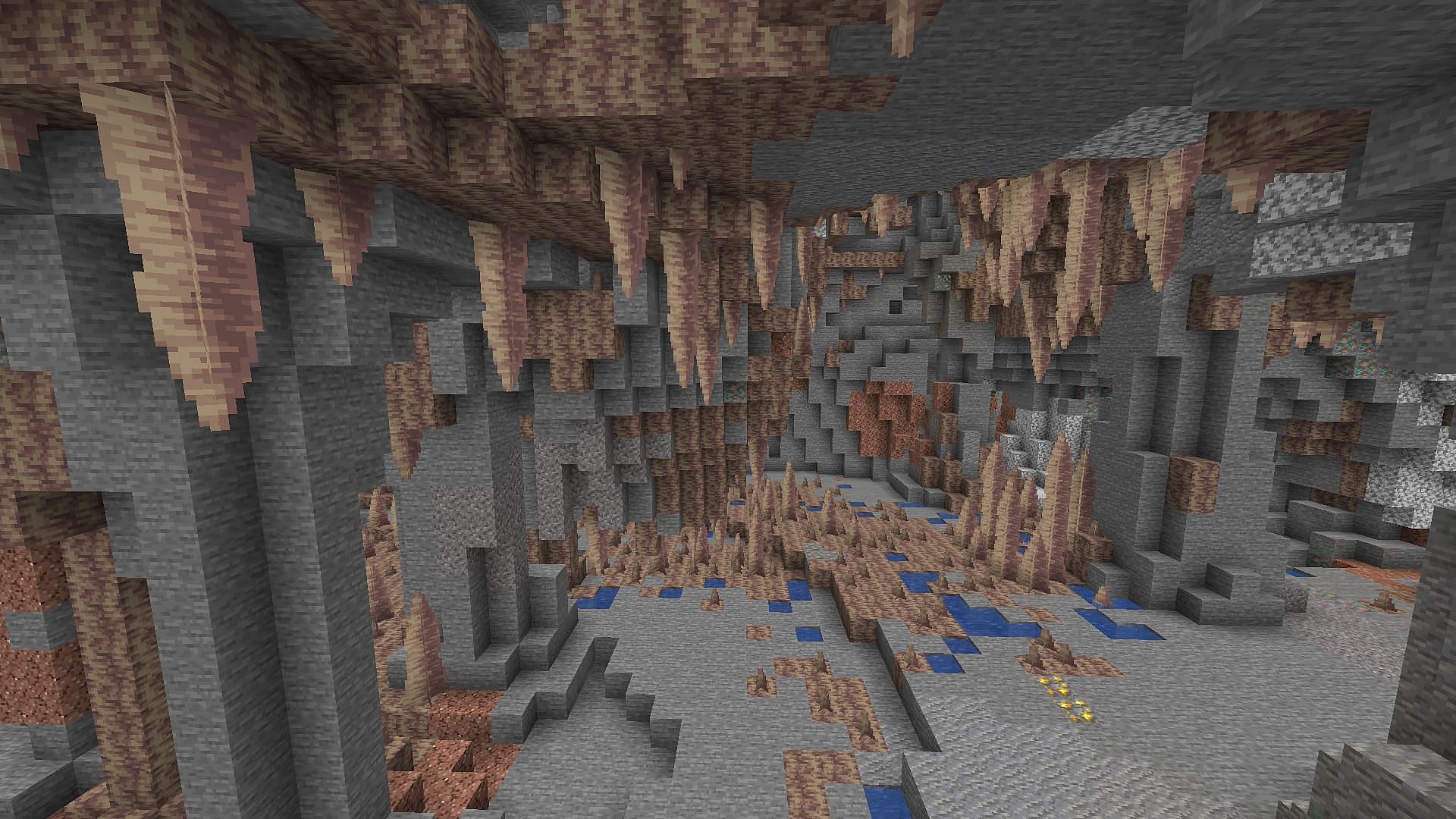 Small wells of water spot the stone flooring of a dripstone cave (Image via Mojang)