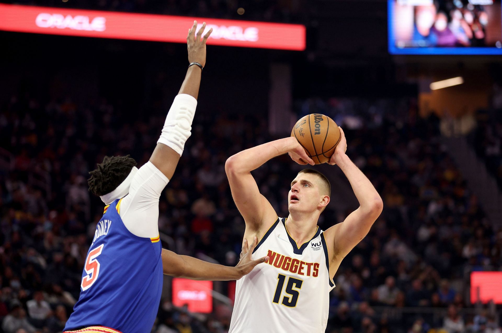 Nikola Jokic attempts a shot over Kevon Looney.