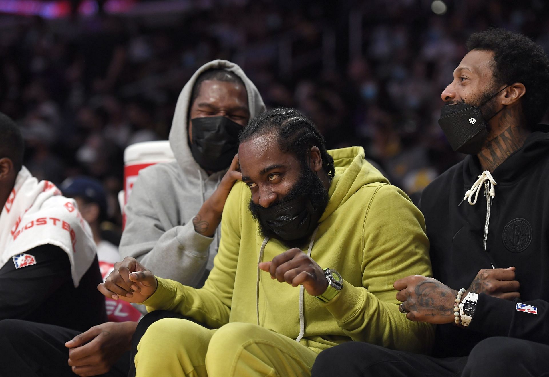 Kevin Durant #7 Kyrie Irving #11 and James Johnson #16 of the Brooklyn Nets laugh on the bench get together during the first half of a preseason game against Los Angeles Lakers at Staples Center on October 3, 2021 in Los Angeles, California.