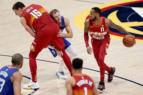 Luke Kennard of the Los Angeles Clippers attempts to get around a screen set by Nikola Jokic of the Denver Nuggets