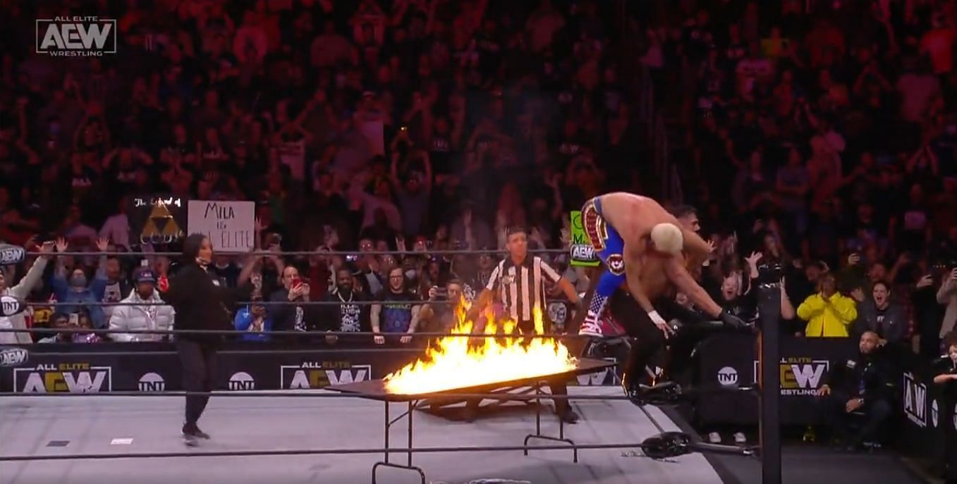 Cody Rhodes preparing to launch Andrade through a flaming table