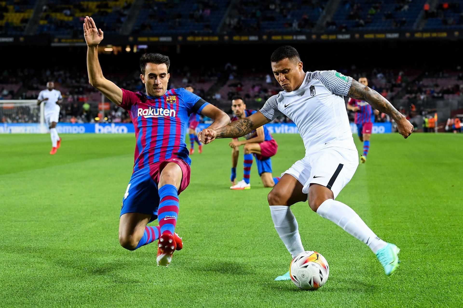 FC Barcelona&#039;s Eric Garcia (L) slides into a challenge against Granada