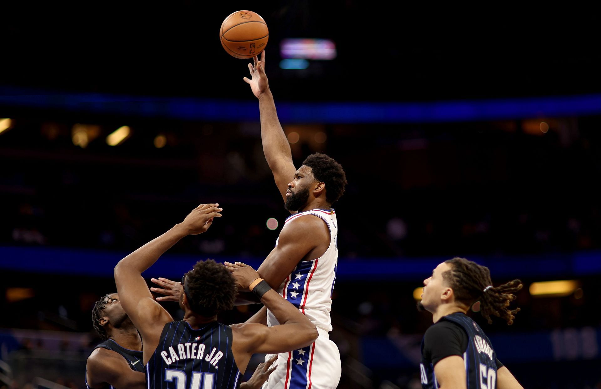 Joel Embiid attempts a tough hook shot over two defenders