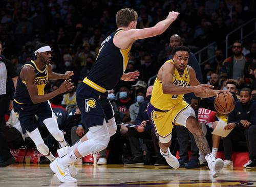 Talen Horton-Tucker #5 of the LA Lakers drives to the basket on Domantas Sabonis #11 and Justin Holiday #8 of the Indiana Pacers during a 111-104 Pacers win at Crypto.com Arena on January 19, 2022 in Los Angeles, California.