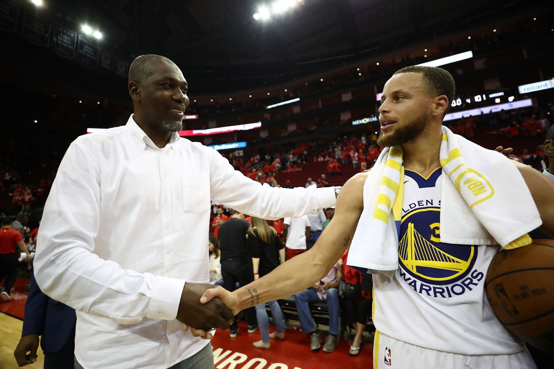 Hakeem Olajuwon (left) shaking hands with Stephen Curry (right)