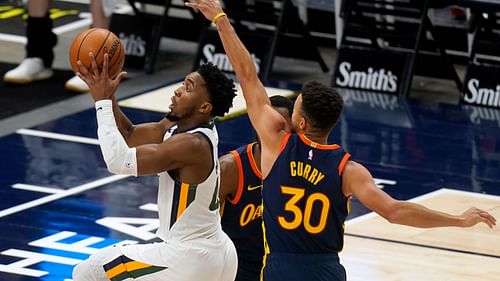 Stephen Curry of the Golden State Warriors tries to block Utah Jazz's Donovan Mitchell [Source: AP]