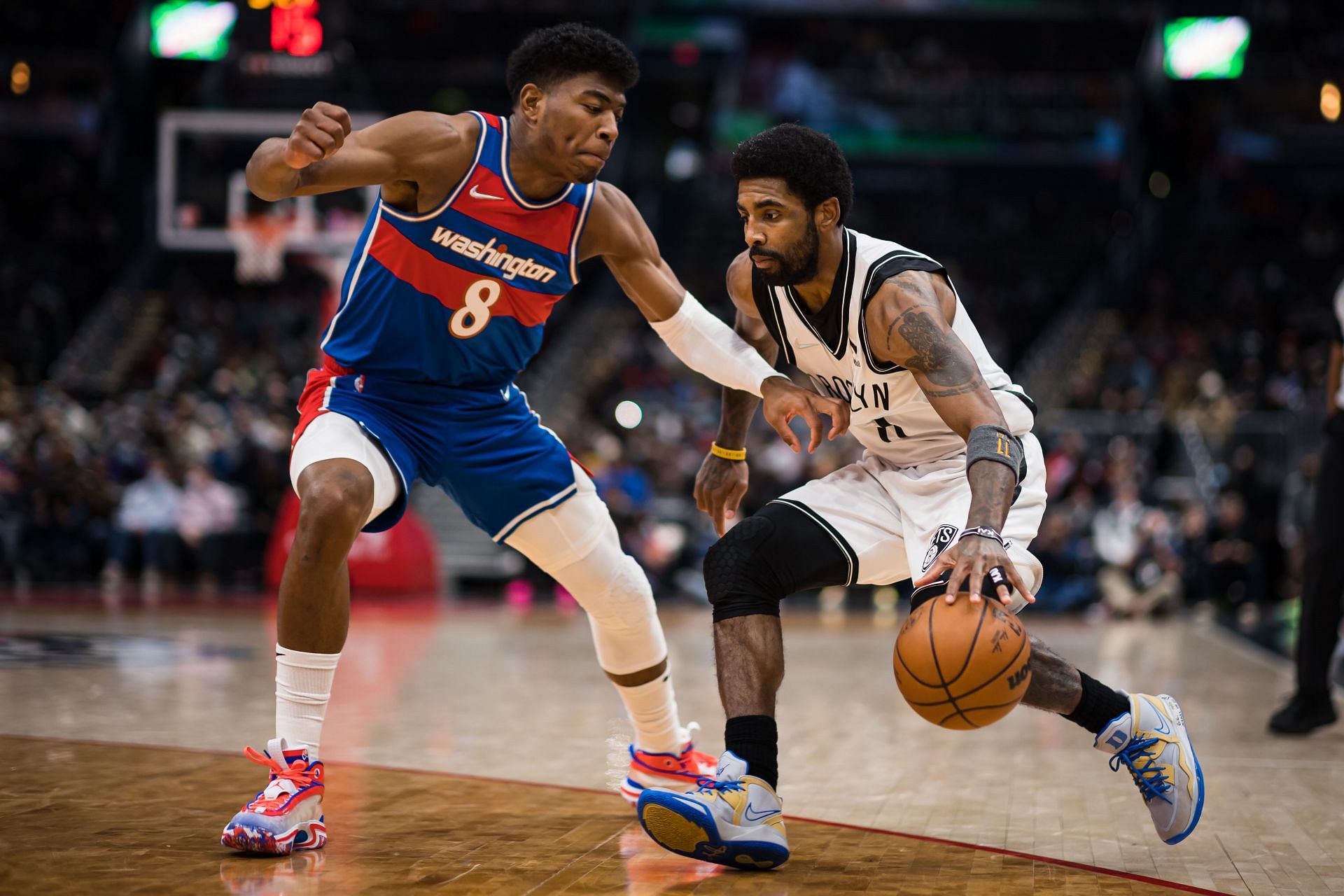 Kyrie Irving of the Brooklyn Nets handles the ball as Rui Hachimura of the Washington Wizards defends.