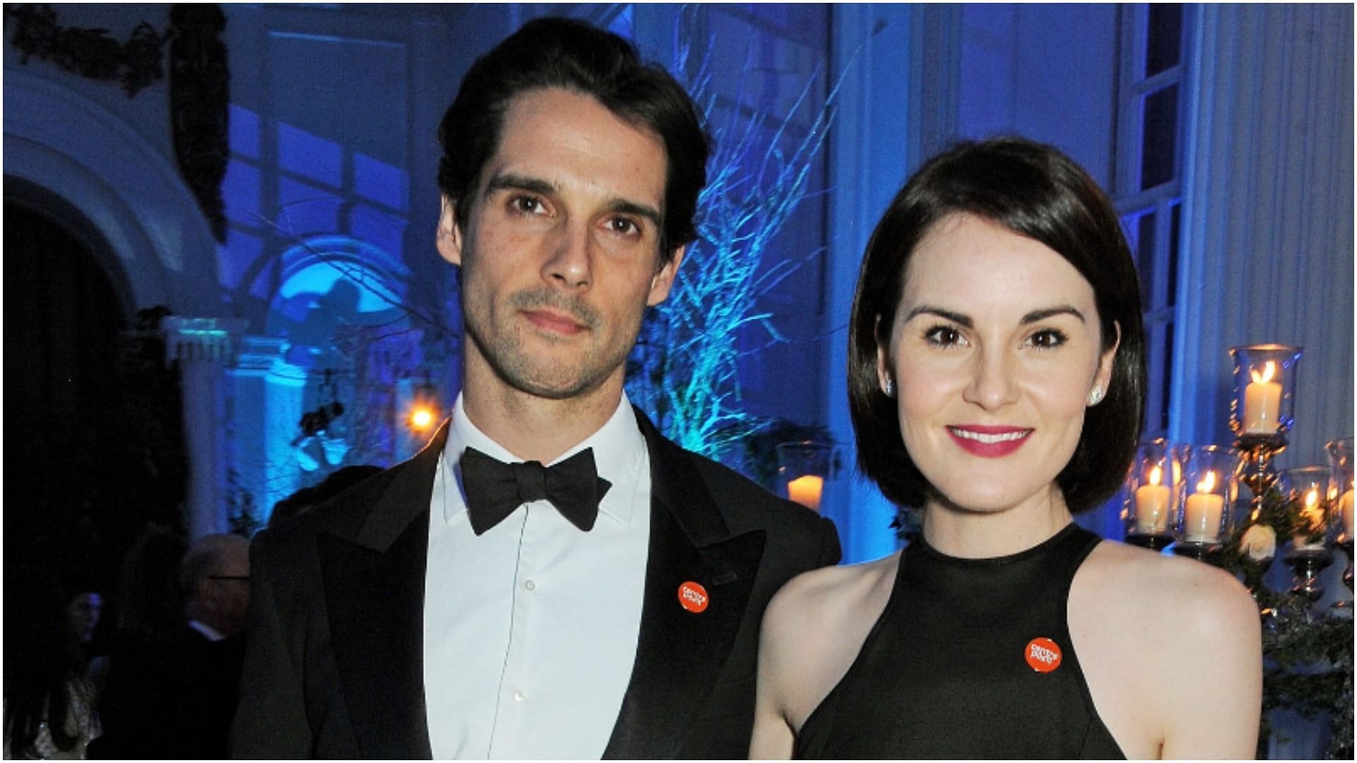 John Dineen and Michelle Dockery attend the Winter Whites Gala in aid of Centrepoint at Kensington Palace (Image via David M. Benett/Getty Images)