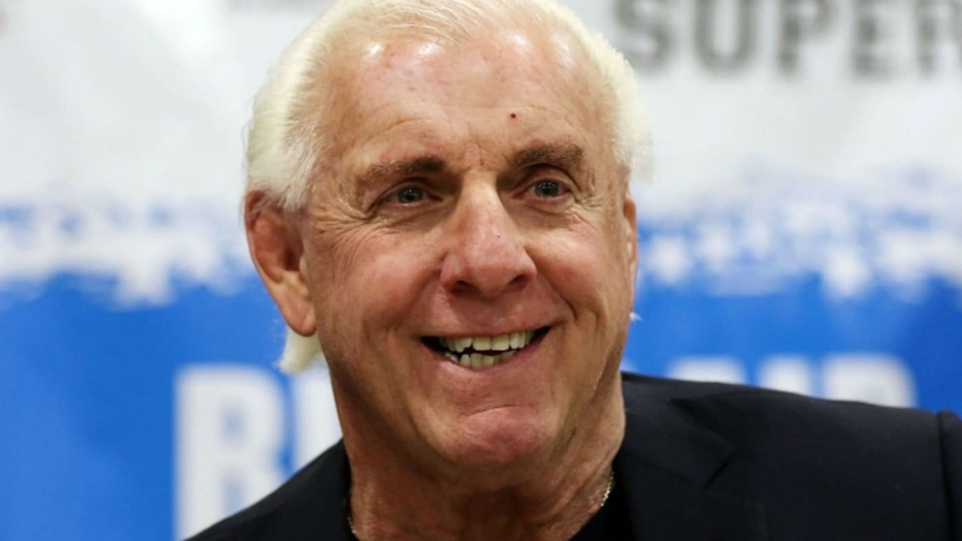 Ric Flair smiling at a fan convention