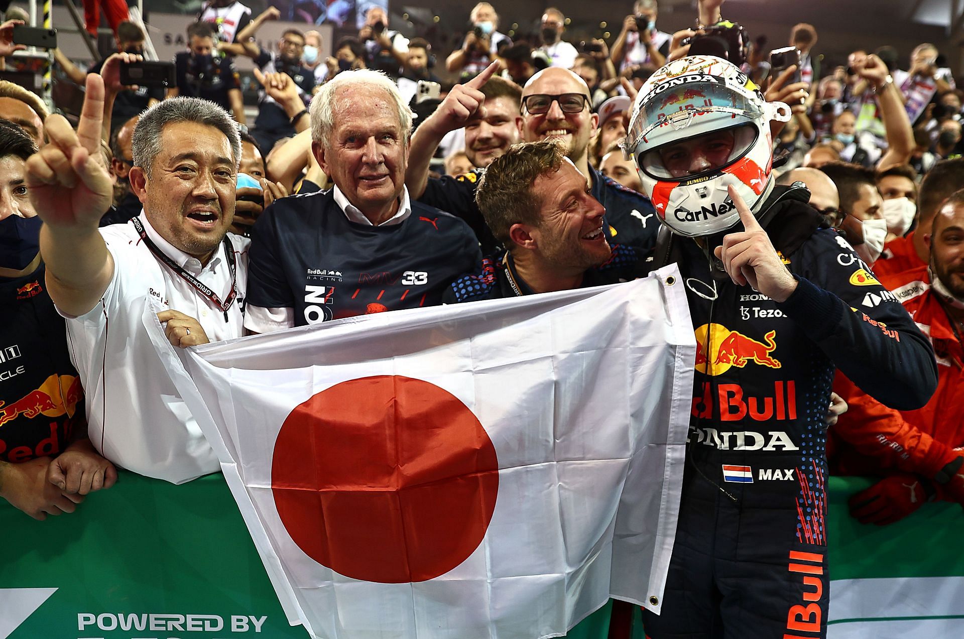 Max Verstappen (right) celebrates with Dr. Helmut Marko (left of center) and Masashi Yamamoto (left) after winning the 2021 Drivers&#039; Championship