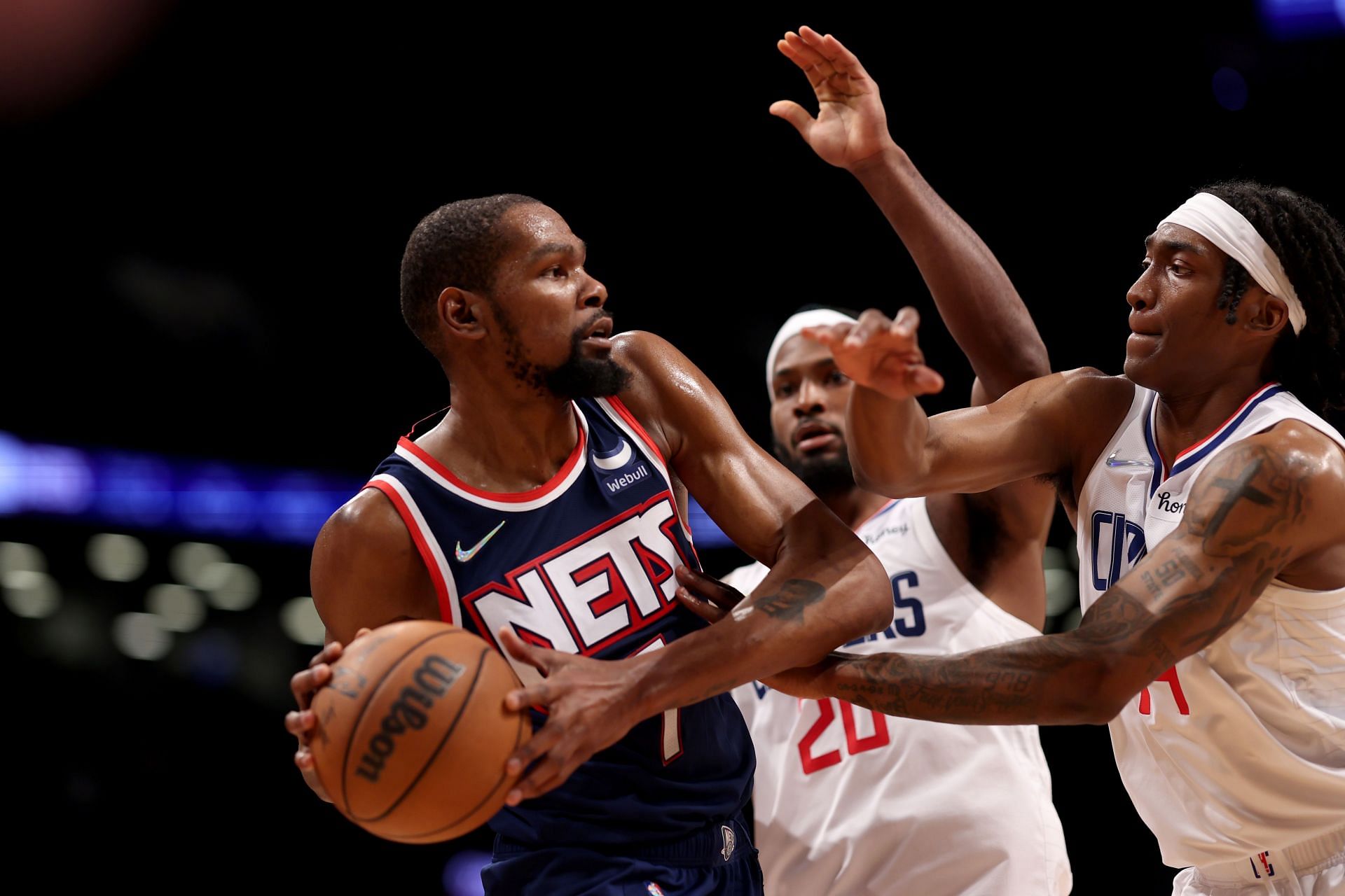 Kevin Durant #7 of the Brooklyn Nets is defended by Terance Mann #14 of the Los Angeles Clippers and Justice Winslow #20