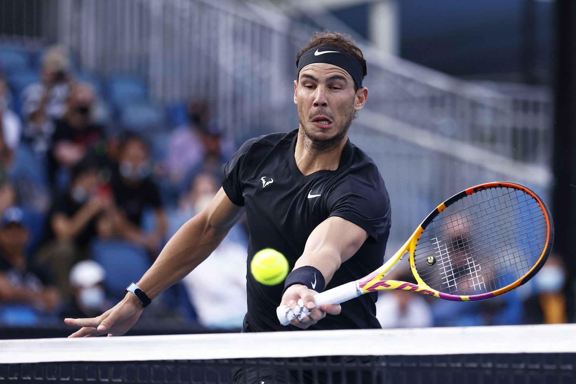 Rafael Nadal plays a forehand volley during his doubles match in Melbourne