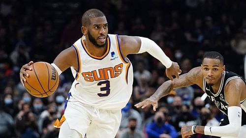 Chris Paul of the Phoenix Suns drives past San Antonio Spurs' Dejounte Murray [Source: Arizona Sports]