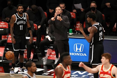 Brooklyn Nets' Kyrie Irving and Steve Nash watch on from the sidelines during an NBA game