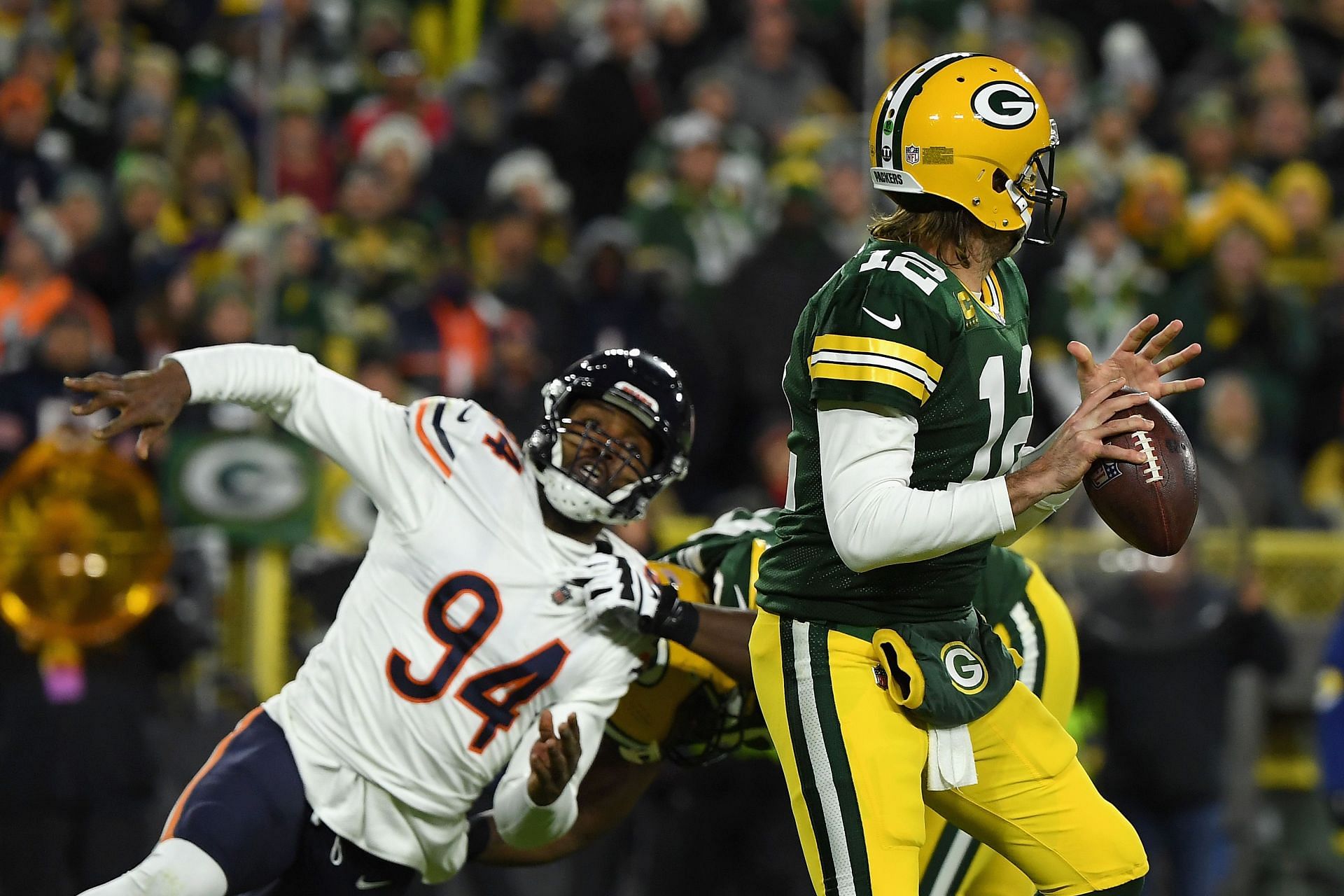 Chicago Bears edge rusher Robert Quinn pursuing Green Bay Packers quarterback Aaron Rodgers