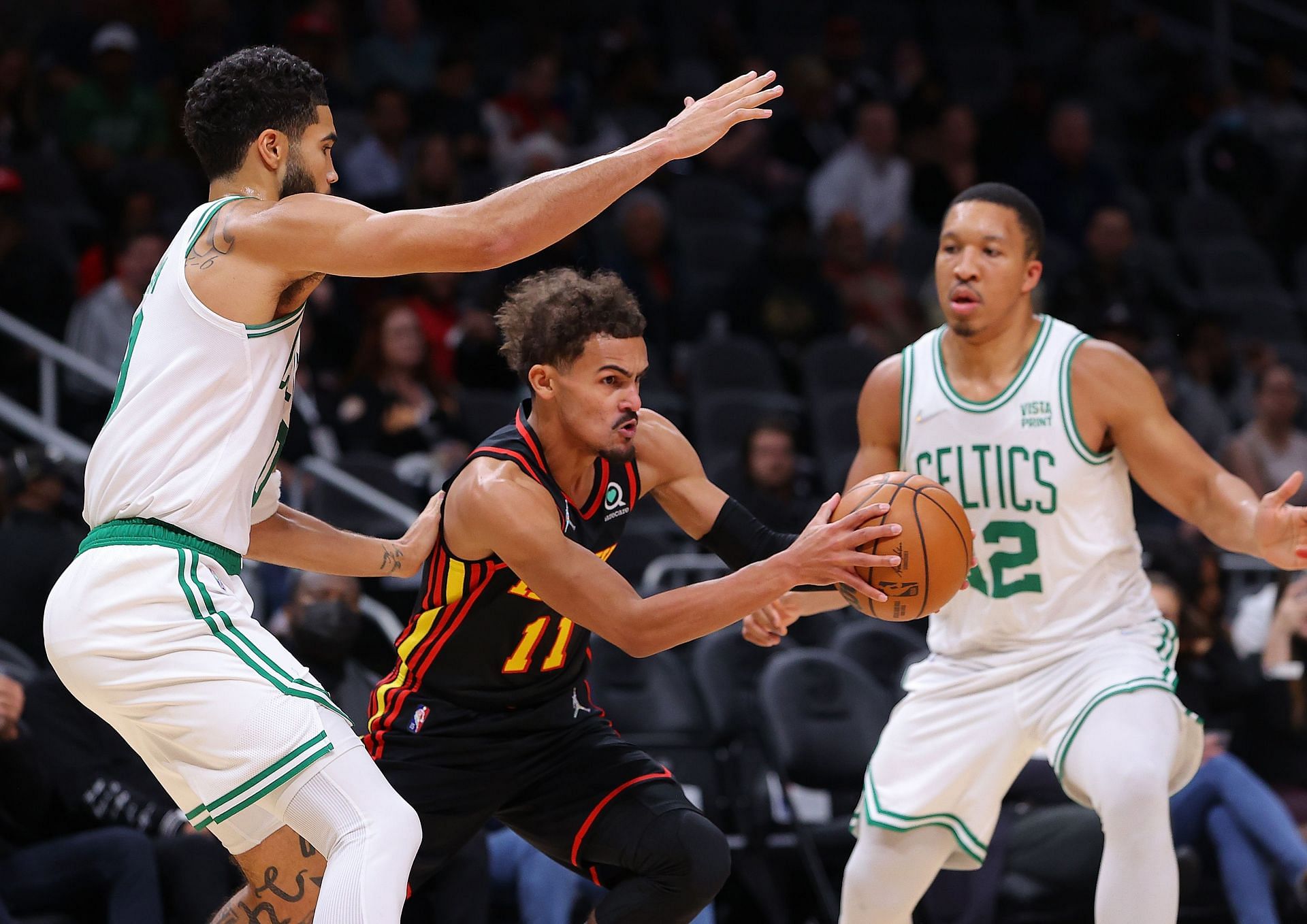 Trae Young #11 of the Atlanta Hawks drives against Jayson Tatum #0 and Grant Williams #12 of the Boston Celtics