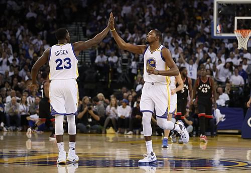 Kevin Durant of the Golden State Warriors high-fives Draymond Green