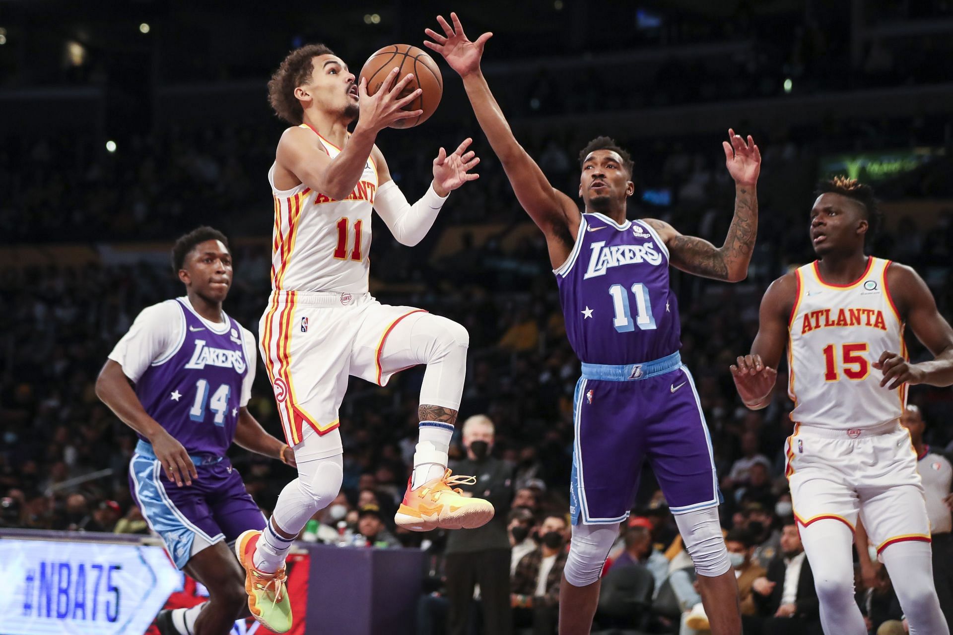 Trae Young #11 of the Atlanta Hawks drives to the basket deffended by Malik Monk #11 of the Los Angeles