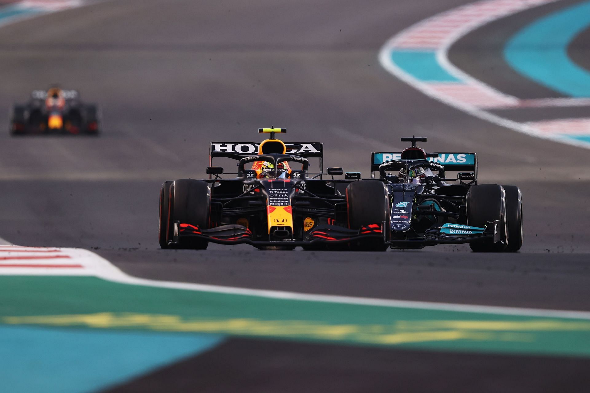 Sergio Perez (left) holds off Lewis Hamilton (right) with Max Verstappen in the distance (Photo by Lars Baron/Getty Images)