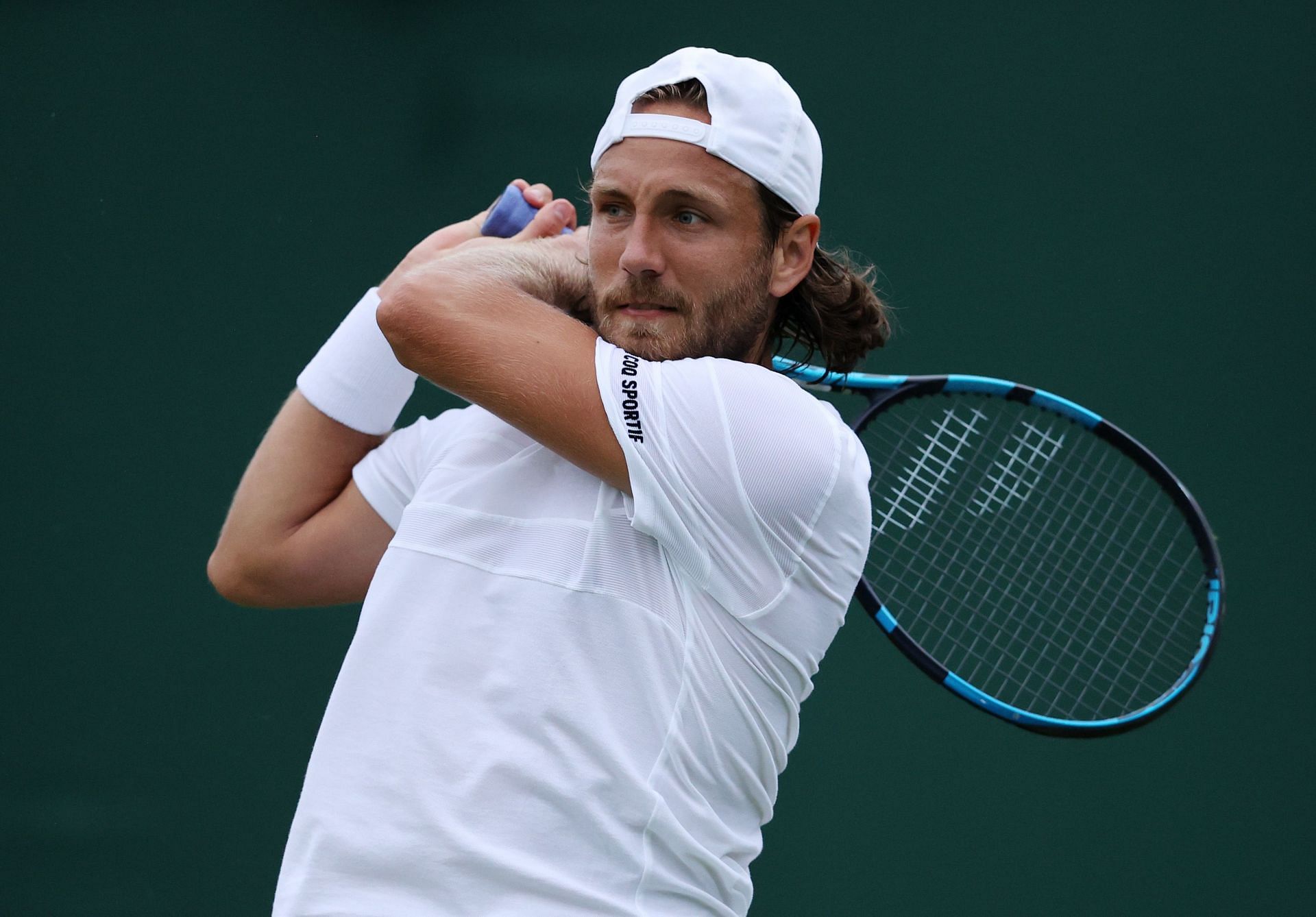 Lucas Pouille plays a backhand at Wimbledon 2021