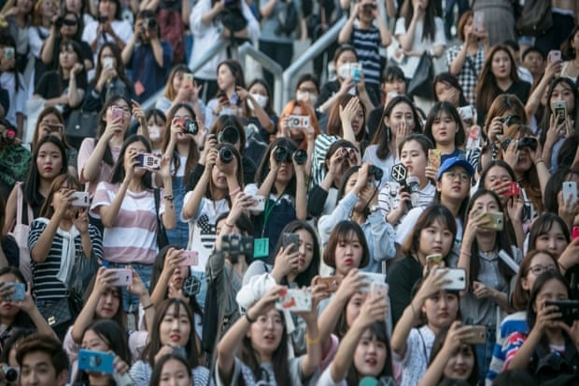 Fans trying to catch a glimpse of K-pop band EXO (Image via Getty Images)